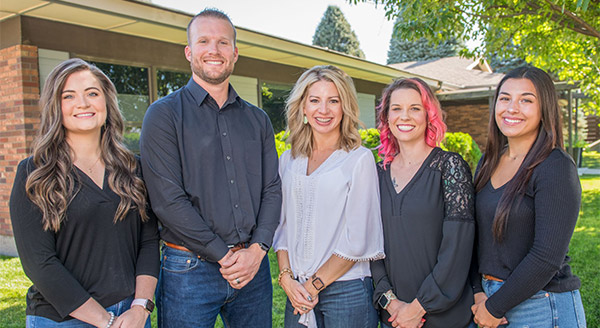 homegrown dental staff smiling outside of building