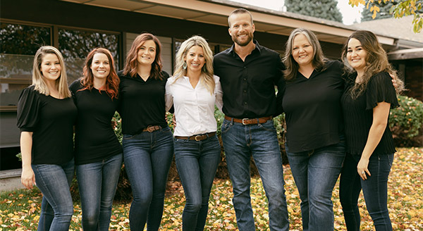 homegrown dental staff smiling outside of building